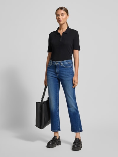 Vrouwenmodel draagt Feminine Fit Jeans in verkorte pasvorm van Marc Cain, blauwe tint, mix van katoen en elastaan, steekzakken, geheel vooraanzicht.
