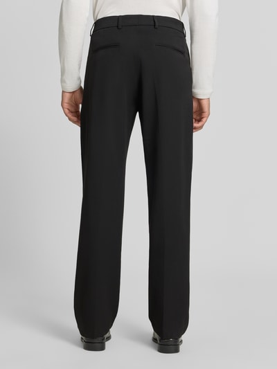 Męski model nosi czarne spodnie Anzughose mit Bügelfalten Model 'Como Solid Slack Pants' von Les Deux z bawełny, krój regular fit, kanty, kieszenie z tyłu, Szerokość w rozmiarze 32/32: 43 cm, Długość wewnętrzna nogawki: 77 cm, widok całej sylwetki z tyłu.