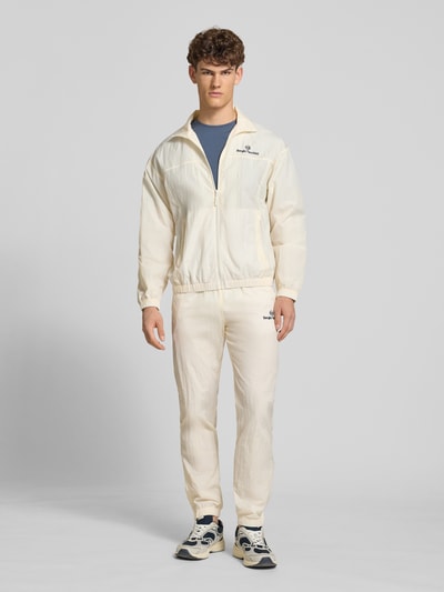 Męski model prezentuje Regular Fit kurtka ze stójką model 'Nayla' od SERGIO TACCHINI, zamek błyskawiczny, wpuszczane kieszenie, elastyczne wykończenia, długość tyłu w rozmiarze M: 69 cm, długość rękawów: 61 cm, jasny kolor, gładka tekstura, fason krój regular fit; zdjęcie całej sylwetki z przodu.