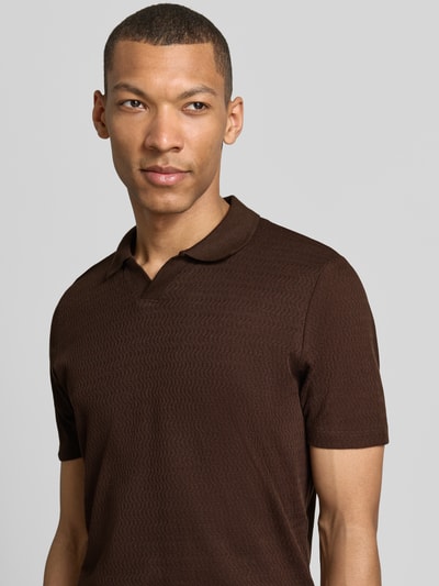 Männermodel trägt Modern Fit Poloshirt mit Polokragen und Label-Detail von MARKUP in Braun, reine Baumwolle, Nahaufnahme Oberkörper.
