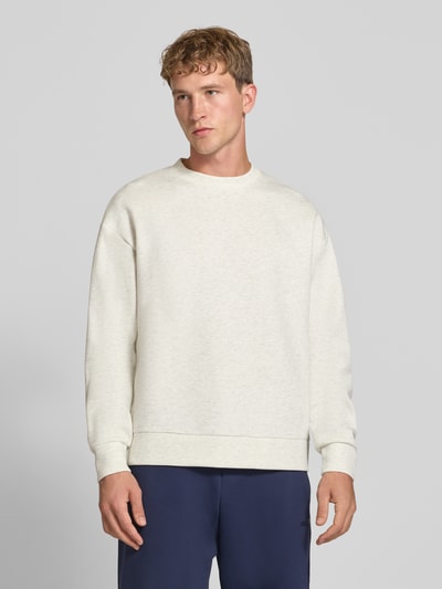 Męski model prezentuje Regular Fit Sweatshirt mit Baumwoll-Anteil od JACK & JONES, mieszanka bawełny, okrągły dekolt, krój regular fit, elastyczne wykończenia, długość tyłu 65 cm, rękawy 59 cm, jasnobeżowy, gładka tekstura, Ganzkörperansicht von vorne.