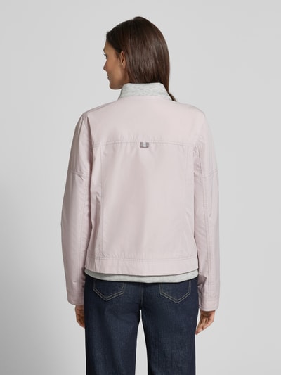 Modelka nosi Jacke mit Zweiwege-Reißverschluss od Amber & June, różowy kolor, krój regular fit, długość tyłu 56 cm, szerokość w rozmiarze 36: 51 cm, stójka, kieszenie na piersi z zamkiem, kieszenie boczne z zapięciem na guzik, długość rękawa 60 cm, szerokość ramion w rozmiarze 36: 42 cm, widok całej sylwetki z tyłu