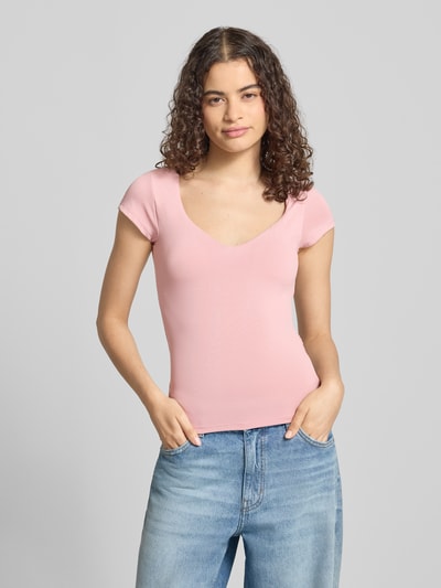 Frauenmodel trägt T-Shirt mit integriertem BH von Gina Tricot in Rosa, Material-Mix mit Stretch-Anteil, Slim-Fit, Rundhalsausschnitt, Rückenlänge 52 cm bei Größe S, Ganzkörperansicht von vorne.