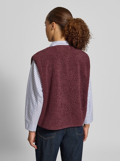 Frauenmodel trägt Regular Fit Weste aus Teddyfell Modell 'Hoktown' von American Vintage in Bordeaux, strukturiertes Material, Ganzkörperansicht Rückansicht. Damen Weste mit Logo-Patch und Knopfleiste, Rückenlänge 57 cm, Schulterbreite 43 cm, Brustweite 63 cm.
