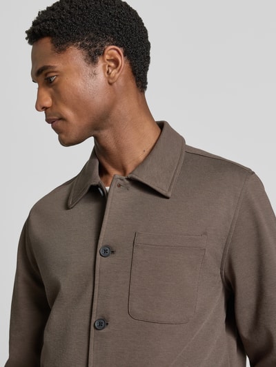 Männermodel trägt Slim Fit Hemdjacke mit Viskose-Anteil von Lindbergh in Braun, sichtbare Brusttasche und Umlegekragen, Nahaufnahme Oberkörper. Elastischer Material-Mix, durchgehende Knopfleiste.