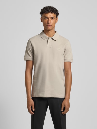 Męskí model nosi Slim Fit Poloshirt aus Baumwoll-Mix von BOSS Orange, efekt: jednolity kolor, krój slim fit, naszywka z logo, kołnierzyk polo, rękaw: krótki rękaw, zakończenie rękawów: prążkowane, wykończenie materiału: pika, mieszanka bawełny, Ganzkörperansicht von vorne.