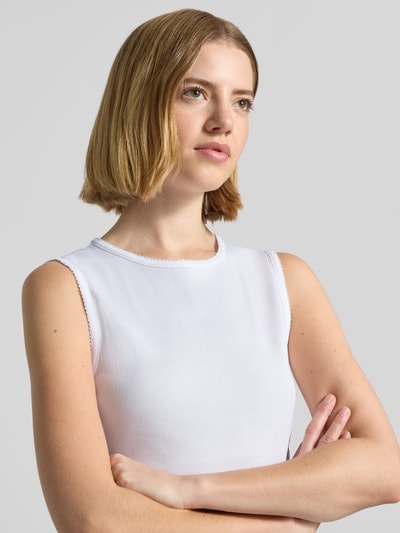 Kobiece modelka nosi top z drobnym prążkowaniem, model 'FARIDA' od Drykorn, bawełna, dopasowany krój, okrągły dekolt, długość tyłu w rozmiarze S: 48 cm, zbliżenie na górną część ciała.