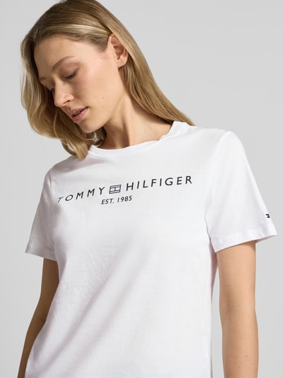 Frauenmodel trägt Regular Fit T-Shirt aus reiner Baumwolle von Tommy Hilfiger in Weiß mit Logo-Detail, Nahaufnahme Oberkörper.