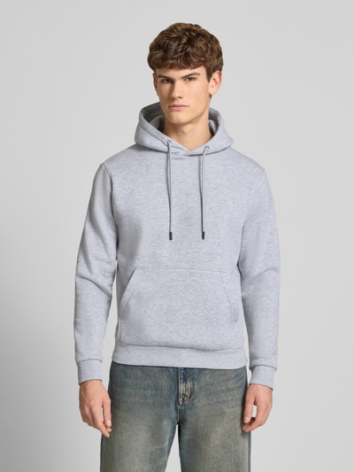 Männermodel trägt Hoodie mit Kapuze Modell 'BRADLEY' von Jack & Jones in Grau, lockerer Schnitt, Känguru-Tasche, Ganzkörperansicht von vorne.