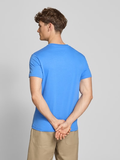 Männermodel trägt Regular Fit T-Shirt aus reiner Baumwolle von Tommy Jeans in Optik: Unifarben, Label-Print, Logo-Stitching, Ganzkörperansicht Rückansicht.