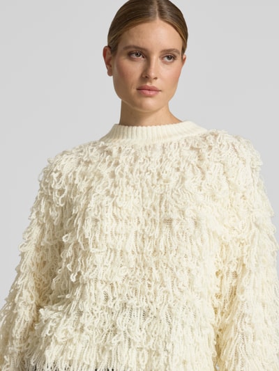 Frauenmodel trägt Strickpullover mit Fransen Modell 'PINAR' von Cph Muse, Woll-Mix in Offwhite, grobe Struktur, Nahaufnahme Oberkörper.
