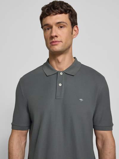 Männermodel trägt Regular Fit Poloshirt mit Label-Stitching von Fynch-Hatton aus reiner Baumwolle, graue Farbe, Nahaufnahme Oberkörper.