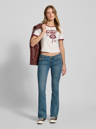 Vrouwenmodel draagt Low Rise Flared Jeans met steekzakken model 'JOEY' van TRUE RELIGION, denimblauw, used-look, Ganzkörpervooraanzicht.
