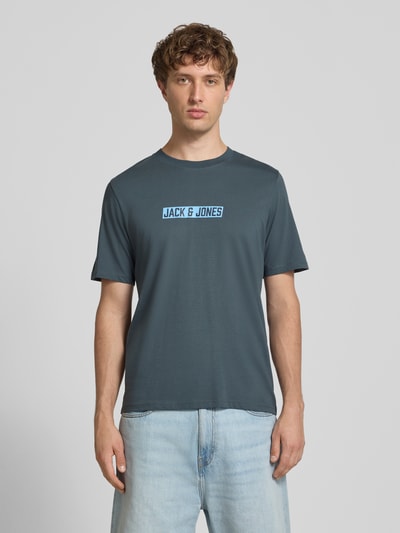 Männermodel trägt Regular Fit T-Shirt mit Logo-Print Modell 'Munk' von JACK & JONES in Blau, reine Baumwolle, Ganzkörperansicht von vorne.