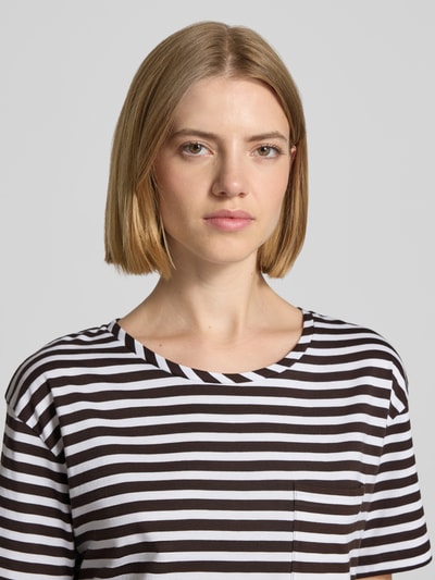 Frauenmodel trägt T-Shirt im Allover-Look mit Rundhalsausschnitt von monari, schwarz-weiß gestreift, reine Baumwolle, Nahaufnahme Oberkörper.