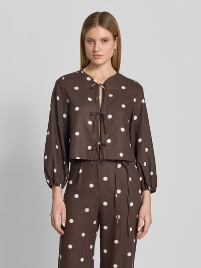 Frauenmodel trägt Regular Fit Bluse mit Zierschleifen von Jake*s Casual, braun mit weißen Punkten, Leinen-Viskose-Mix, Rundhalsausschnitt, eingefasste Ärmelabschlüsse, langärmeliges Design, Ganzkörperansicht von vorne.