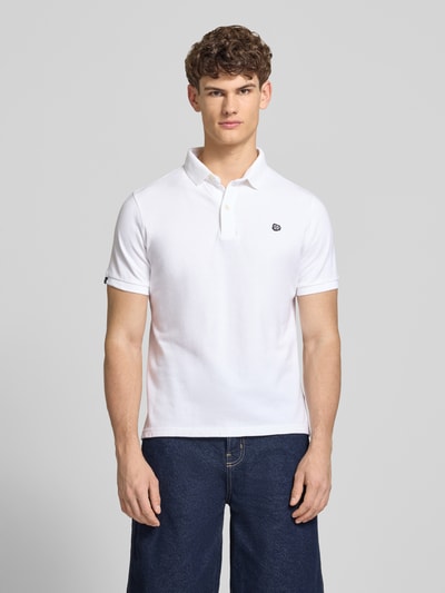 Męski model nosi Regular Fit Poloshirt mit Logo-Stitching od Superdry, czysta bawełna, krój regular fit, polokołnierzyk, krótki rękaw, długość pleców w rozmiarze M: 67 cm, widok całej sylwetki z przodu.