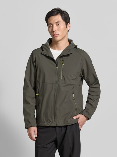 Männermodel trägt Regular Fit Jacke mit mit Logo-Applikation von Killtec w kolorze oliwkowym, wpuszczane kieszenie z zamkiem błyskawicznym, aplikacja z logo, kaptur z tunelem, kieszeń napoleonka, długość tyłu w rozmiarze M 72 cm, szerokość ramion w rozmiarze M 45 cm, szerokość klatki piersiowej w rozmiarze M 57 cm, długość rękawów w rozmiarze M 67 cm, gładka tekstura, widok na całe ciało z przodu