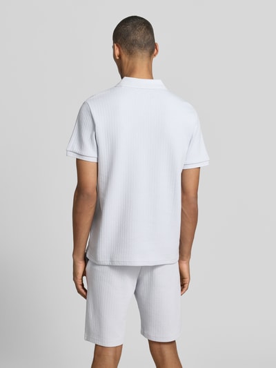 Männermodel trägt Regular Fit Strick-Poloshirt mit V-Ausschnitt von MCNEAL aus Baumwoll-Mix mit Stretch-Anteil, Ganzkörperansicht Rückansicht.