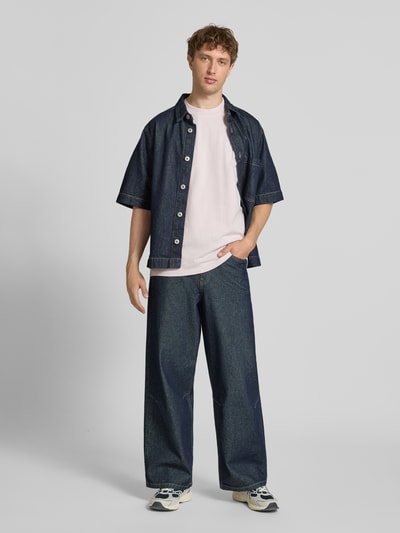 Männermodel trägt Oversized T-Shirt mit Label-Stitching von Pegador aus reiner Baumwolle, Herren T-Shirt, Rundhalsausschnitt, Ganzkörperansicht von vorne. Rückenlänge bei Größe M: 70 cm.