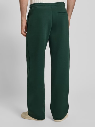 Männermodel trägt Regular Fit Sweatpants mit Gesäßtasche von REVIEW in Dunkelgrün, Baumwoll-Mix, elastischer Bund, Ganzkörperansicht Rückansicht.