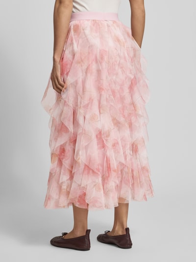 Vrouwenmodel draagt A-Lijn maxi-rok met ruchesafwerking model 'SKY' van Only, allover bloemenprint, tule, regular fit, maxi, elastische tailleband, volant zoom, geheellichaamsbeeld achterkant.