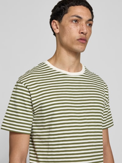 Männermodel trägt T-Shirt mit Rundhalsausschnitt von Closed in Grün-Weiß gestreift, reine Baumwolle, Nahaufnahme Oberkörper.