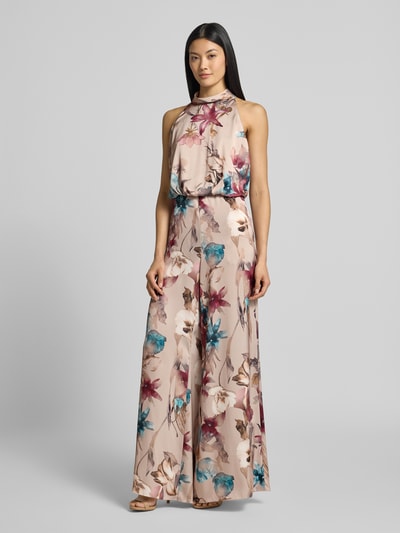 Kobiece model prezentuje Relaxed Fit Jumpsuit mit floralem Allover-Print od Vera Mont z satyny, krój taliowany, stójka, bez rękawów, kwiatowy nadruk, długość tyłu w rozmiarze 36: 43 cm, szerokość w rozmiarze 36: 45 cm, całkowita długość w rozmiarze 36: 148 cm, długość wewnętrzna nogawki: 83 cm, pastelowe kolory, szerokie nogawki, gładka powierzchnia, kwiatowe wzory, widok całej sylwetki z przodu.