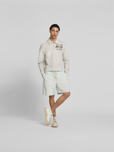 Männermodel trägt Shorts mit aufgesetzten Taschen von Kenzo aus reiner Baumwolle im Relaxed-Fit, Produktdetails sichtbar, Ganzkörperansicht von vorne.