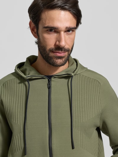 Mannelijk model draagt Regular Fit Trainingsjacke met Jacquard elementen model 'ACTIVE PUSH' van BOSS Green in olijfgroen, Nahaufnahme Oberkörper.