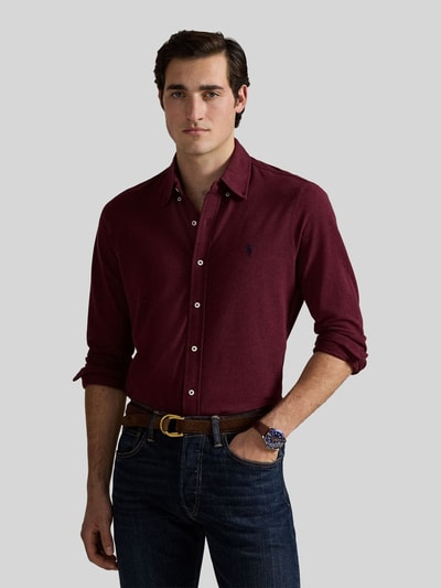 Męski model nosi Regular Fit Freizeithemd aus reiner Baumwolle von Polo Ralph Lauren w kolorze burgundowym, gładka tekstura, pełny widok z przodu.