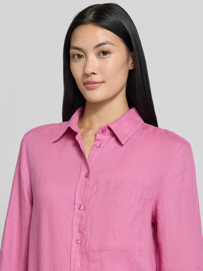 Frauenmodel trägt Leinenbluse mit Brusttasche Modell 'LINO' von MANGO in Pink, Knopfleiste und Hemdblusenkragen, Nahaufnahme Oberkörper.