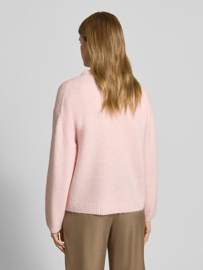 Vrouwenmodel draagt Gebreide pullover met wol van Gina Tricot in lichtroze, los model met ribboorden, materiaalmix, ruglengte 59 cm, mouwlengte 66 cm, Ganzkörperansicht Rückansicht.