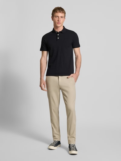 Männermodel trägt Slim Fit Poloshirt mit Viskose-Anteil Modell 'Paulos' von JACK & JONES, Baumwoll-Mix, schwarz, Ganzkörperansicht von vorne.