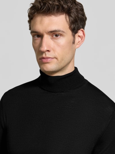 Männermodel trägt Slim Fit Rollkragenpullover aus reiner Baumwolle von Matinique in Schwarz, feine Struktur, Nahaufnahme Oberkörper.
