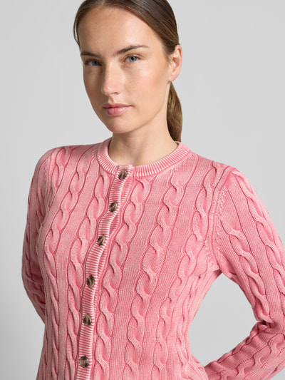 Frauenmodel trägt Relaxed Fit Strickjacke aus reiner Baumwolle von Jake*s Casual in Rosa, Zopfmuster, Nahaufnahme Oberkörper.