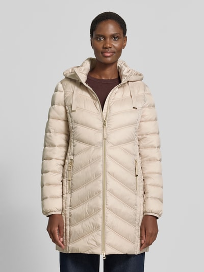 Modelka kobieca nosi Steppmantel mit Zweiwege-Reißverschluss von Christian Berg Woman Selection, beżowy, krój slim fit, kaptur z troczkiem, kieszenie na zamek, długość pleców w rozmiarze 36: 83 cm, szerokość ramion w rozmiarze 36: 40 cm, szerokość klatki piersiowej w rozmiarze 36: 48 cm, długość rękawa w rozmiarze 36: 65 cm, ujęcie całej sylwetki z przodu.