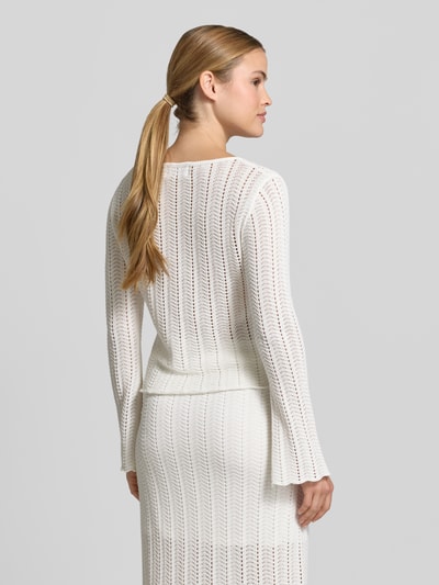 Frauenmodel trägt Cardigan mit V-Ausschnitt und Knopfleiste von Rich & Royal aus Reine Baumwolle, Straight Fit, Trompetenärmel, Ajour-Strick, Rückenlänge 52 cm, Ärmellänge 62 cm, cremeweiß mit feiner Textur, Ganzkörperansicht Rückansicht.