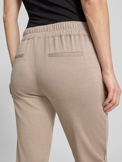 Frauenmodel trägt Skinny Fit Stoffhose mit Viskose-Anteil Modell 'NANNI' von FREE/QUENT in Beige, glatte Struktur, Detailaufnahme Rückansicht. Damen Stoffhose Elastikbund, Eingrifftaschen, verkürztes Bein, 7/8-Länge, fixierte Beinabschlüsse, Bundweite 41 cm, Innenbeinlänge 68 cm.