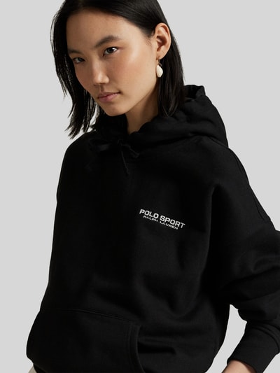 Vrouwenmodel draagt Relaxed Fit Hoodie aus Baumwoll-Mix van Polo Ralph Lauren in effen kleuren met labelopschrift, kangoeroezak, capuchon met tunnelkoord, lange mouwen, geribde rompzoom en mouwboord, gemaakt van sweat met katoenmix. Nahaufnahme bovenlichaam.