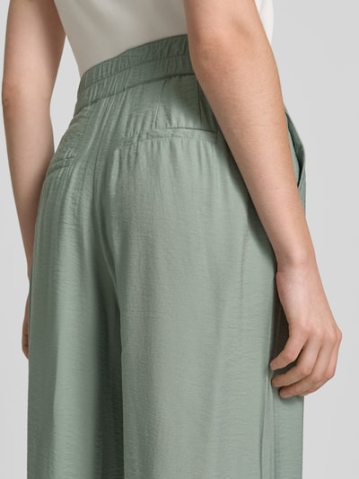 Frauenmodel trägt Wide Fit Chino aus Viskose-Mix mit Gesäßtaschen von Betty Barclay in hellem Grün, feine Struktur, Detailaufnahme Rückansicht, Damen Chino, Haken- und Reißverschluss, Bundweite 36 cm, Innenbeinlänge 80 cm, Größe 36.