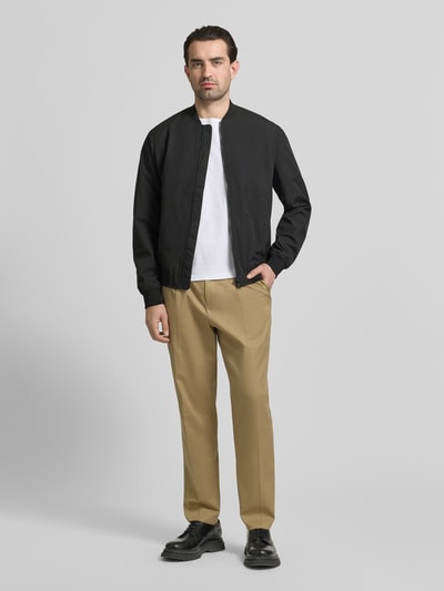 Mannenmodel draagt Regular Fit Bomberjacke mit Stehkragen van MCNEAL, zwart, elastische mix, steekzakken, volledige voorkantansicht.