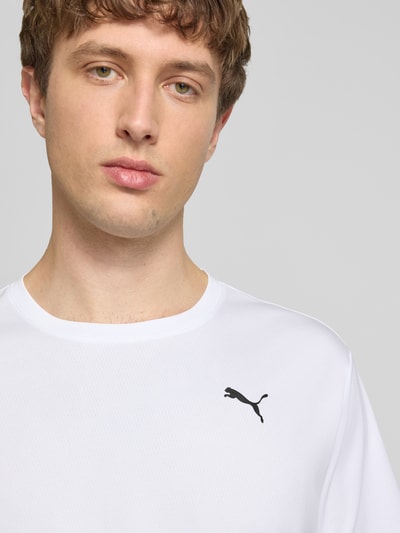 Männermodel trägt TRAINING T-Shirt mit Label-Detail Modell von PUMA PERFORMANCE in Weiß, Kurzärmelig, Rundhalsausschnitt, Nahaufnahme Oberkörper.