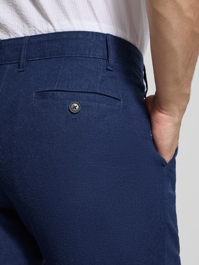 Mężczyzna nosi Hose aus Leinen-Viskose-Mix mit Eingrifftaschen von Christian Berg Men, intensywnie granatowy kolor, mieszanka lnu i wiskozy, krój regular fit, wpuszczane kieszenie, zapięcie na guzik i zamek błyskawiczny, Szerokość w rozmiarze 50: 47 cm, długość wewnętrzna nogawki w rozmiarze 50: 78 cm, detaliczny widok z tyłu.