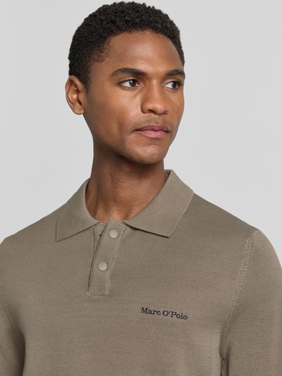 Mężczyznę model nosi Regular Fit Poloshirt aus reiner Baumwolle Marc O'Polo × DFB Travel Collection, efekt: jednolity kolor, aplikacja: wyhaftowane logo i naszywka z logo, kołnierzyk polo, zapięcie na 2 guziki, krótki rękaw, wykończenie materiału: dzianina, skład: bawełna, Nahaufnahme górnej części ciała.