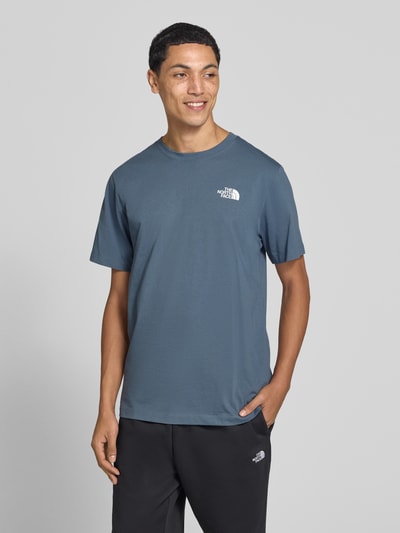 Männermodel trägt T-Shirt mit Label-Print Modell 'Evolution' von The North Face in Blau, Baumwoll-Mix, Regular Fit, Nahaufnahme Oberkörper, Rückenlänge bei Größe M: 73 cm.