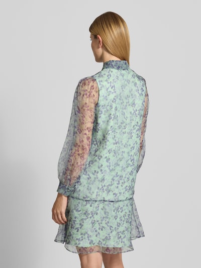 Modelka kobieca ma na sobie knielanges Kleid aus Seide mit Knopfleiste od Marc Cain, czysta jedwab, prosty krój, długość do kolan, wzór na całej powierzchni, półprzezroczysty materiał, kołnierzyk koszulowy, listwa guzikowa, długość tyłu w rozmiarze 36: 94 cm, szerokość w rozmiarze 36: 50 cm, długość rękawów w rozmiarze 36: 64 cm; całkowita sylwetka tyłem