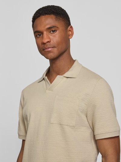 Männermodel trägt Regular Fit Poloshirt aus Baumwoll-Mix von s.Oliver RED LABEL in Beige, strukturierte Seersucker-Optik, Nahaufnahme Oberkörper.