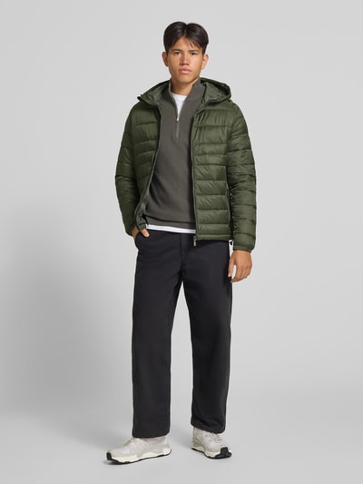 Męski model ma na sobie Regular Fit kurtkę z efektem pikowania Model 'KINGSLEY' od JACK & JONES, kaptur, zamek błyskawiczny, wpuszczane kieszenie, długość tyłu w rozmiarze M: 70 cm, szerokość ramion w rozmiarze M: 45 cm, szerokość klatki piersiowej w rozmiarze M: 52 cm, długość rękawów w rozmiarze M: 67 cm, cała sylwetka widoczna z przodu.