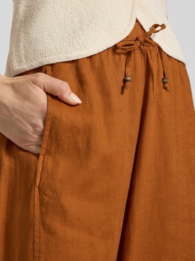 Frauenmodel trägt Leinenhose in verkürzter Passform mit elastischem Bund von Christian Berg Woman, rostbraun, lockere Struktur, Nahaufnahme Oberkörper, Damen, Tunnelzug, Wide-Leg-Pants, reine Leinen, Bundweite Größe 36: 38 cm, Innenbeinlänge 64 cm.